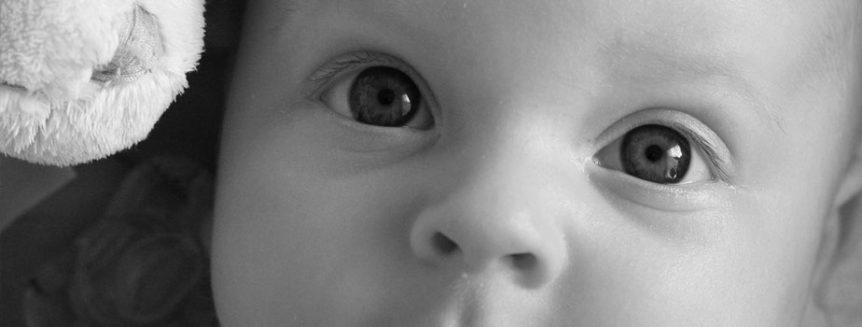A tightly cropped photo of a baby gazing at the viewer