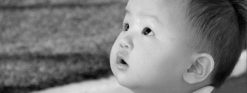 A baby gazes upward with wide eyes.
